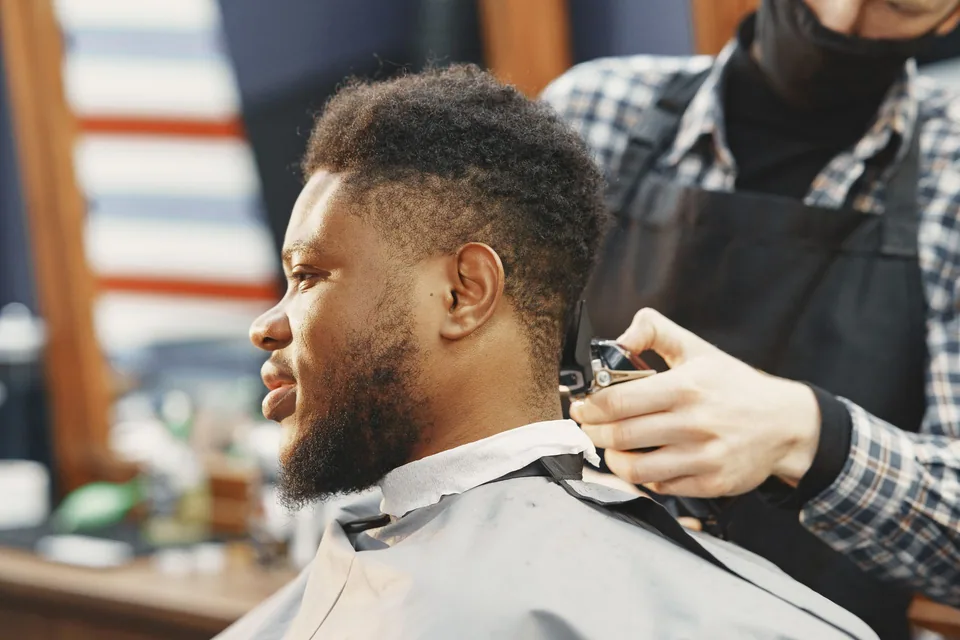 Barber shaping and trimming a man's hair