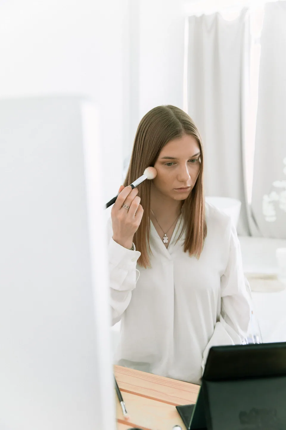 Woman applying makeup with a soft brush